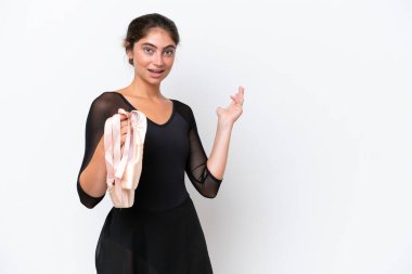 Beyaz arka planda izole edilmiş beyaz bale yapan genç beyaz kadın davet edilmek için ellerini yana uzatıyor.