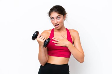 Beyaz arka planda halter kaldıran genç beyaz kadın şaşırdı ve şaşırdı.