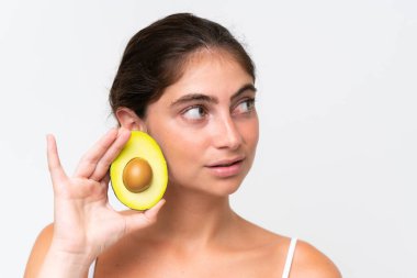 Beyaz arka planda izole edilmiş, elinde avokado tutan beyaz bir kadın. Portreyi kapat