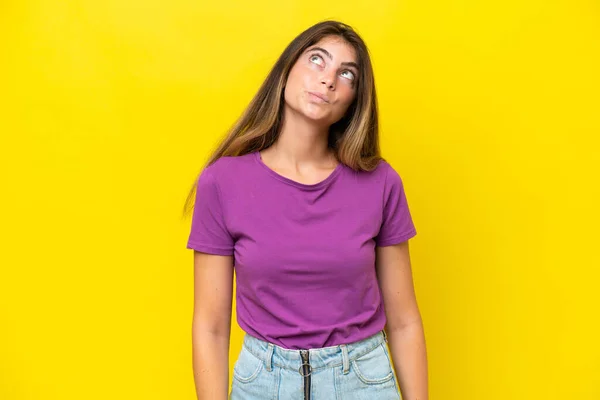 Mulher Caucasiana Jovem Isolado Fundo Amarelo Olhando Para Cima — Fotografia de Stock