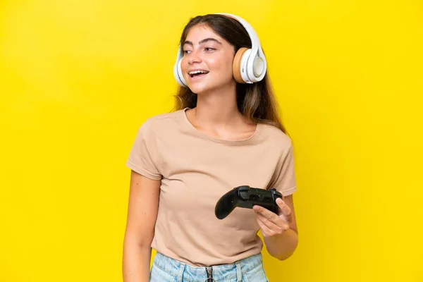 Junge Kaukasische Frau Spielt Mit Einem Videospielcontroller Isoliert Auf Gelbem — Stockfoto