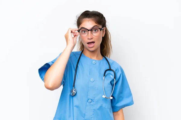 Jonge Verpleegkundige Arts Vrouw Geïsoleerd Witte Achtergrond Met Bril Verrast — Stockfoto