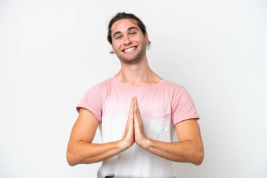 Caucasian handsome man isolated on white background keeps palm together. Person asks for something
