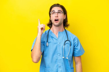 Genç cerrah beyaz adam sarı arka planda izole edilmiş.