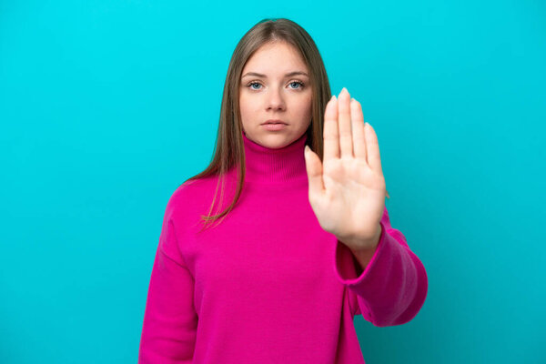 Young Lithuanian woman isolated on blue background making stop gesture