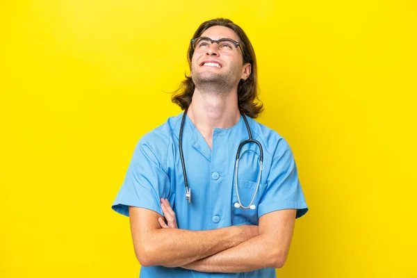 年轻的外科医生高加索人 背景黄黄 面带微笑地抬起头 — 图库照片