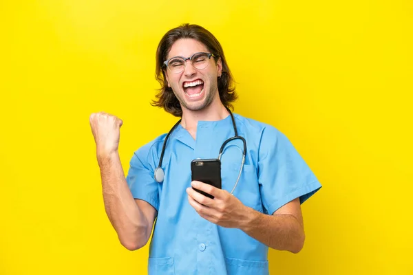 Ung Kirurg Kaukasisk Man Isolerad Gul Bakgrund Med Telefon Seger — Stockfoto