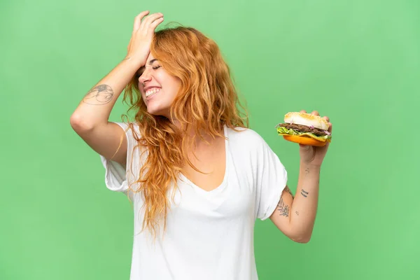 Junge Kaukasische Frau Hält Einen Burger Isoliert Auf Grünem Bildschirm — Stockfoto