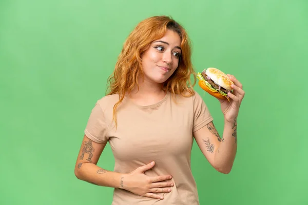 Jeune Femme Caucasienne Tenant Hamburger Isolé Sur Fond Chroma Écran — Photo