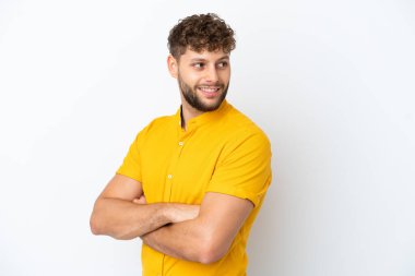 Beyaz arka planda soyutlanmış yakışıklı beyaz bir adam yan tarafa bakıyor ve gülümsüyor.