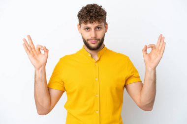 Zen pozisyonunda beyaz arka planda izole edilmiş yakışıklı beyaz bir adam.