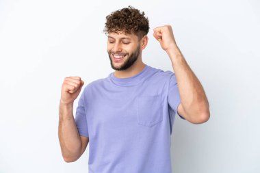 Beyaz arka planda izole edilmiş yakışıklı beyaz adam zaferi kutluyor.