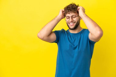 Sarı arka planda izole edilmiş yakışıklı beyaz adam gülüyor.