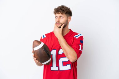 Beyaz arka planda ragbi oynayan Kafkasyalı genç adamın şüpheleri var.