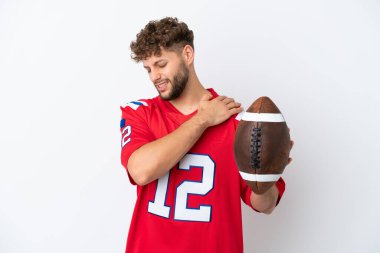 Beyaz arka planda ragbi oynayan beyaz tenli genç bir adam çabaladığı için omuz ağrısı çekiyor.