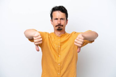 Young man with moustache isolated on white background showing thumb down with two hands