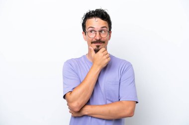 Young man with moustache isolated on white background thinking an idea while looking up