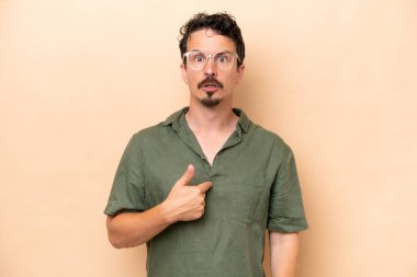 Beyazların arka planında izole edilmiş genç bir beyaz adam kendini işaret ediyor.
