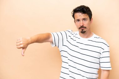 Beyazlı genç bir adam bej arka planda izole edilmiş.