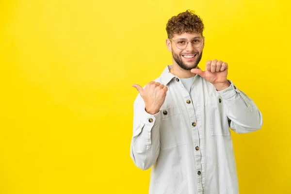 Young Handsome Caucasian Man Isolated Yellow Background Pointing Side Present — Stock Photo, Image