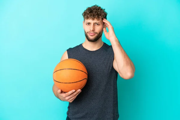 Guapo Joven Jugando Baloncesto Aislado Sobre Fondo Azul Teniendo Dudas —  Fotos de Stock