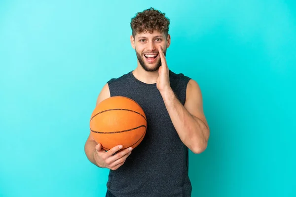 Guapo Joven Jugando Baloncesto Aislado Sobre Fondo Azul Con Sorpresa —  Fotos de Stock