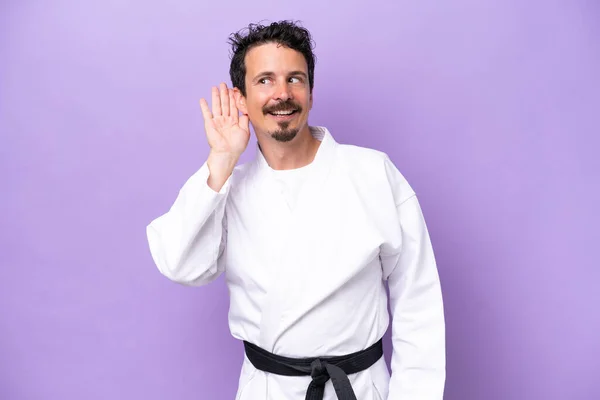 Joven Hombre Caucásico Haciendo Karate Aislado Sobre Fondo Púrpura Escuchando — Foto de Stock