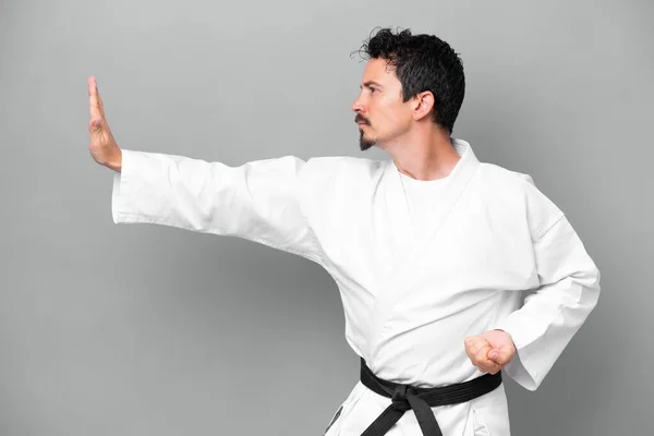 Joven Caucásico Aislado Sobre Fondo Gris Haciendo Karate —  Fotos de Stock