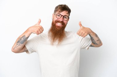 Kızıl saçlı, uzun sakallı adam beyaz arka planda izole edilmiş bir şekilde baş parmak hareketi yapıyor.