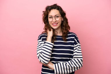 Pembe arka planda izole edilmiş genç beyaz kadın gülüyor.