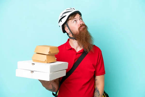 Dodávka Muž Drží Pizzy Burgery Izolované Modrém Pozadí Vzhlíží — Stock fotografie