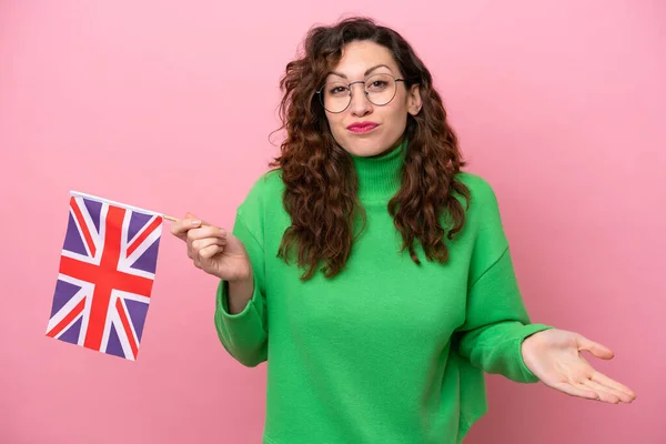 Mladá Běloška Drží Anglickou Vlajku Izolované Růžovém Pozadí Dělat Pochybnosti — Stock fotografie