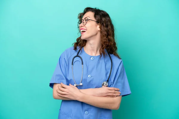 年轻的护士高加索女人在蓝色背景上孤立无援 快乐而微笑 — 图库照片