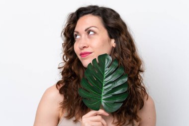 Beyaz arka planda, elinde palmiye yaprağı olan beyaz bir kadın. Portreyi kapat