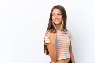 Beyaz arka planda izole edilmiş küçük beyaz kız bir ürünü sunmak için kenarı işaret ediyor.