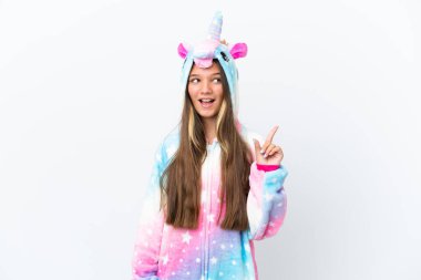 Beyaz arka planda izole edilmiş, tek boynuzlu at pijaması giyen küçük beyaz kız parmağını yukarı kaldıran bir fikir düşünüyor.