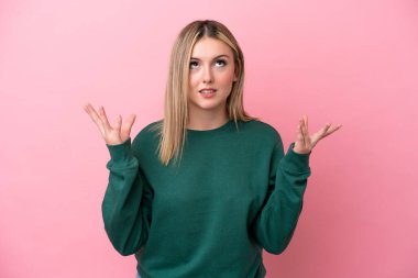 Pembe arka planda izole edilmiş genç beyaz kadın bunalıma girdi.