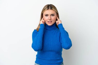 Beyaz arka planda izole edilmiş genç beyaz kadın hayal kırıklığına uğramış ve kulaklarını kapatmış.