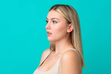 Mavi izole bir arka planda güzel bir genç kadının portresi.