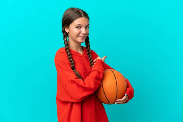 Маленькая Белая Девочка Играет Баскетбол Голубом Фоне Указывая Назад — стоковое фото