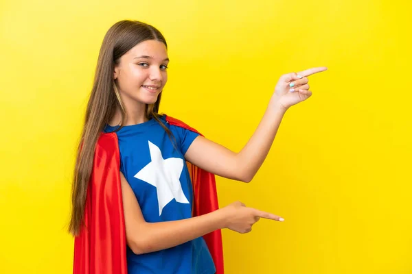 Klein Kaukasisch Superheld Meisje Geïsoleerd Gele Achtergrond Wijzend Vinger Naar — Stockfoto