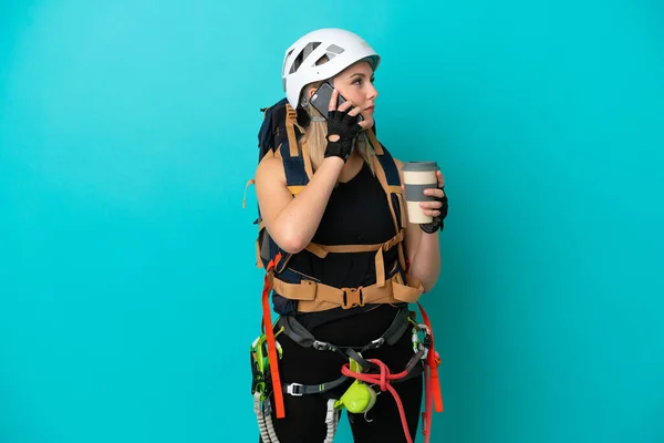 Νεαρή Καυκάσια Ορειβάτισσα Γυναίκα Απομονωμένη Μπλε Φόντο Κρατώντας Καφέ Για — Φωτογραφία Αρχείου