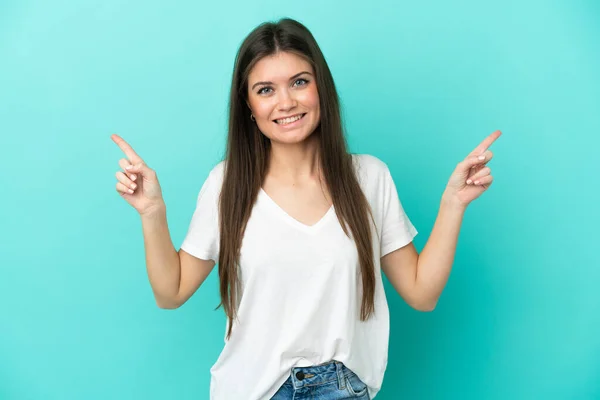 青い背景に指を指差す若い白人女性と幸せ — ストック写真