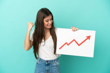 Mavi arka planda izole edilmiş beyaz bir kadın elinde büyüyen bir istatistik okuyla bir işaret tutuyor ve zaferi kutluyor.