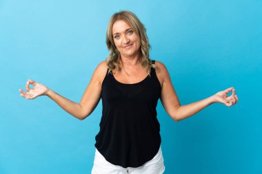 Zen pozunda soyutlanmış orta yaşlı sarışın kadın.