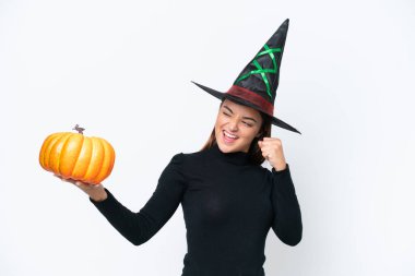 Beyaz arka planda izole edilmiş bir balkabağı tutan cadı kostümü. Zaferi kutluyorlar.