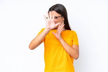 Beyaz arka planda izole edilmiş genç beyaz kadın ellerini öne uzatıyor.