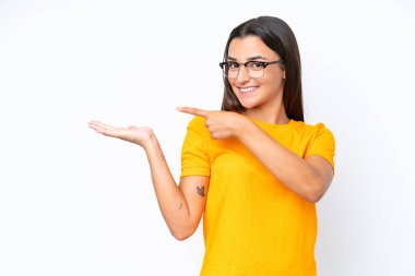 Beyaz arka planda izole edilmiş genç beyaz kadın bir ilan vermek için avucunun içinde hayali bir fotokopi makinesi tutuyor.