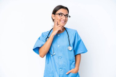 Genç hemşire, beyaz arka planda izole edilmiş bir şekilde yukarı bakarken bir fikir düşünüyor.