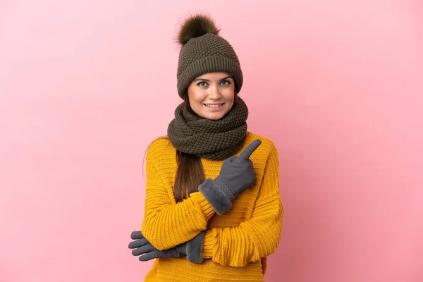 Ung Kaukasisk Flicka Med Vinter Hatt Isolerad Rosa Bakgrund Pekar — Stockfoto